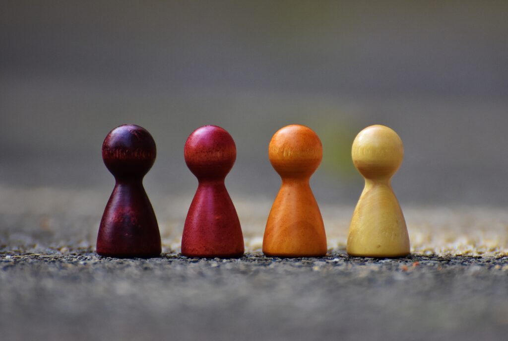  Four wooden pawn figurines in a row.